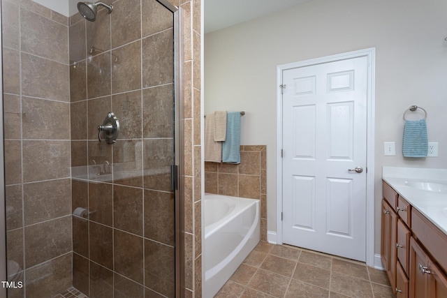 full bathroom featuring a shower stall, vanity, a bath, and tile patterned floors