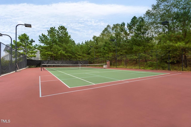 view of tennis court featuring community basketball court and fence