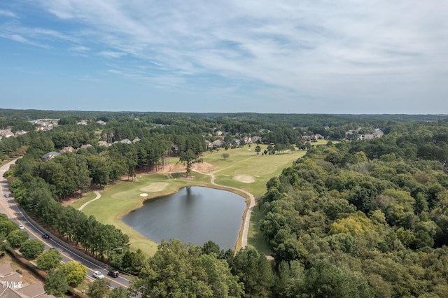 view of property location with a large body of water, a local golf course, and a forest