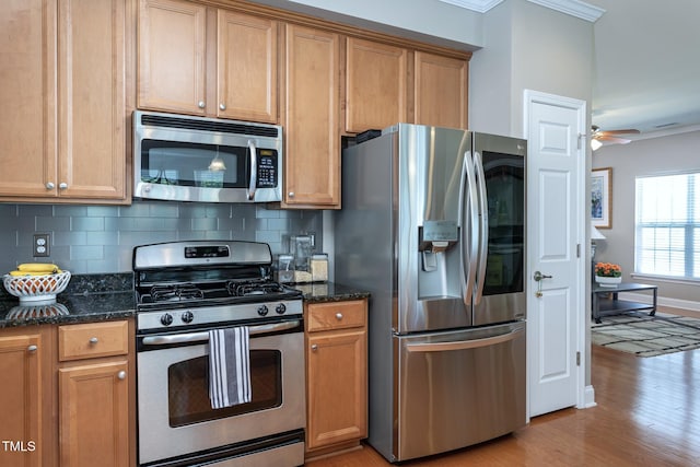 3827 Heritage Spring Cir, Wake Forest, NC 27587 - kitchen with stainless steel appliances, ornamental molding, light wood-style floors, tasteful backsplash, and dark stone counters