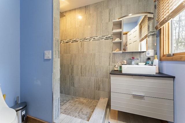 bathroom with a walk in shower, vanity, and toilet