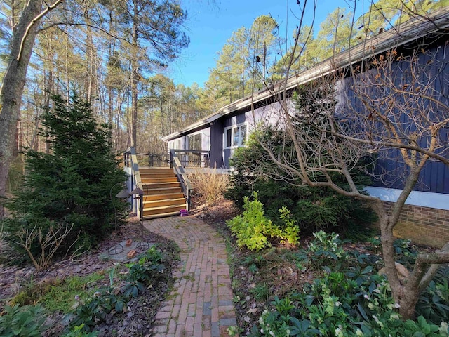 view of side of home with stairway and a deck
