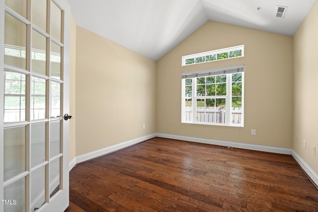 unfurnished room with dark wood-type flooring, vaulted ceiling, and baseboards