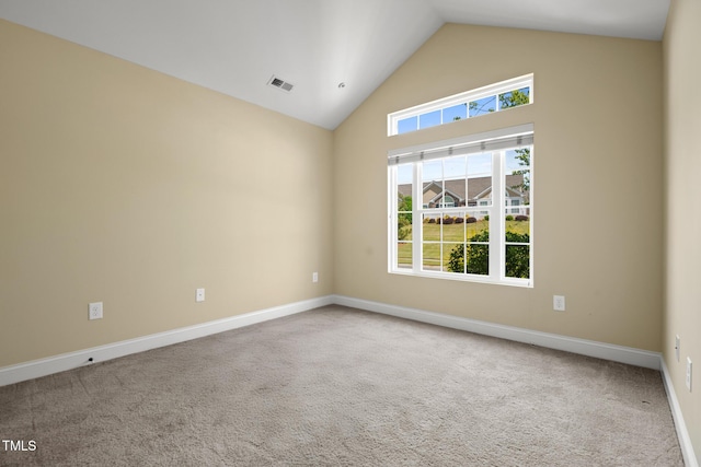 empty room with high vaulted ceiling, carpet flooring, and baseboards