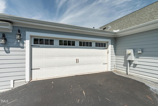 garage featuring asphalt driveway