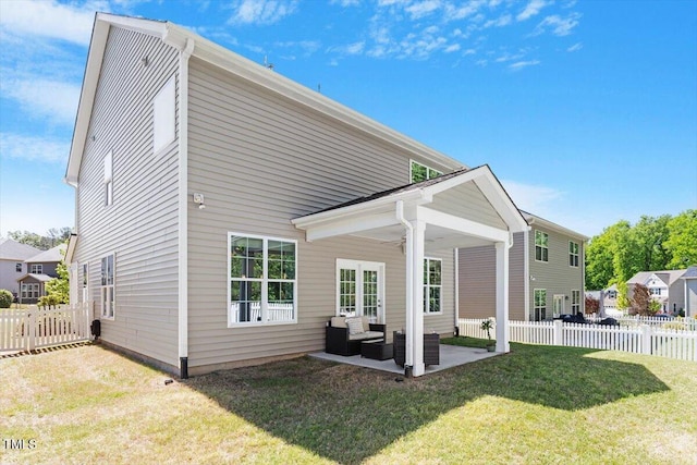 back of house featuring ceiling fan, outdoor lounge area, a fenced backyard, a patio area, and a lawn