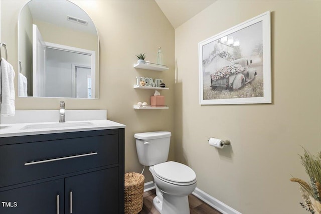 bathroom featuring visible vents, vanity, wood finished floors, toilet, and baseboards