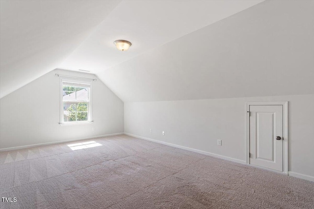 additional living space with carpet floors, baseboards, and lofted ceiling