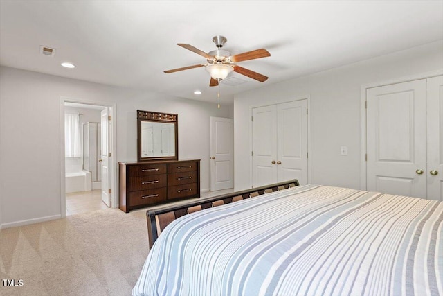 bedroom with two closets, recessed lighting, light colored carpet, and visible vents