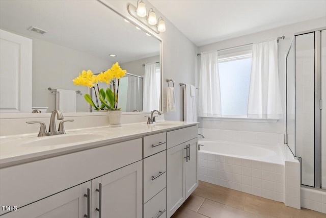 bathroom featuring visible vents, a sink, and a shower stall