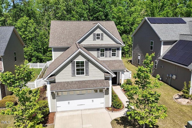 view of front of house featuring a garage, fence, driveway, and a shingled roof