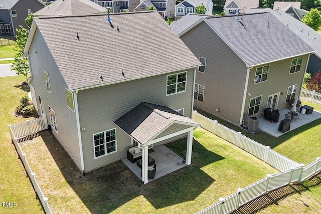 back of property with a residential view, a fenced backyard, a yard, and a patio area