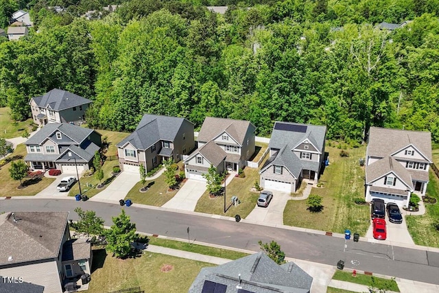 birds eye view of property featuring a residential view and a wooded view