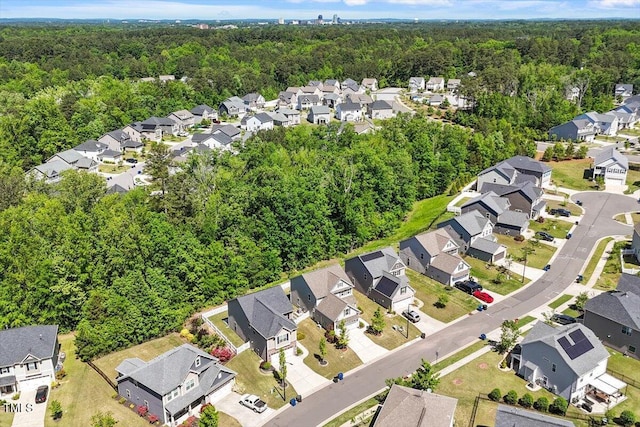 drone / aerial view featuring a residential view and a wooded view