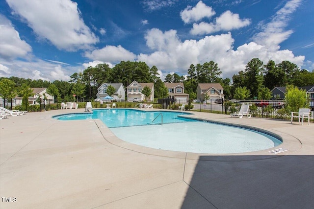 community pool with fence and a patio area