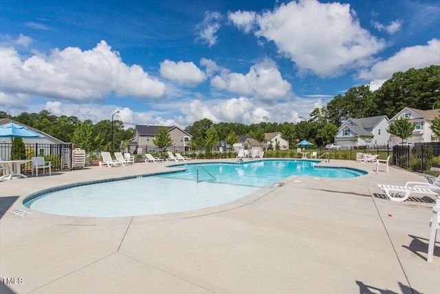 community pool featuring a patio and fence