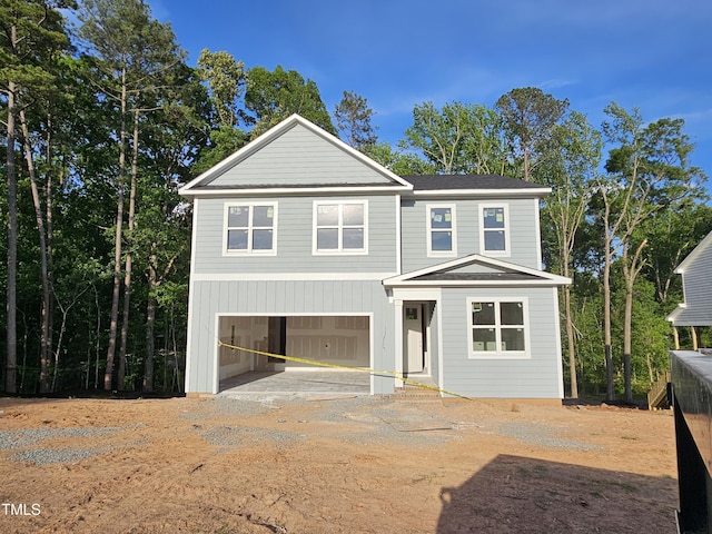 view of front of home featuring a garage and dirt driveway