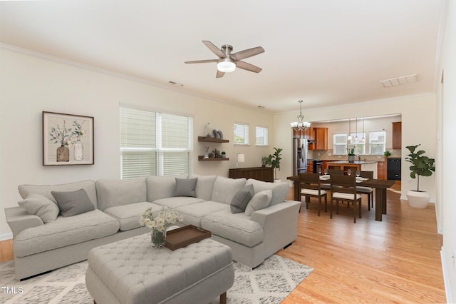 1522 Palmer Hill Dr, Durham, NC 27703 - living room with ornamental molding, ceiling fan with notable chandelier, light wood-style flooring, and visible vents
