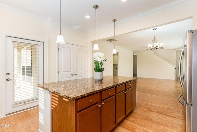 1522 Palmer Hill Dr, Durham, NC 27703 - kitchen with brown cabinets, a notable chandelier, light wood-style flooring, freestanding refrigerator, and visible vents
