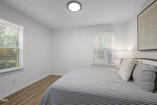 1613 Kilmer Ter, Durham, NC 27703 - bedroom with a textured ceiling, baseboards, and wood finished floors