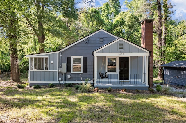 1613 Kilmer Ter, Durham, NC 27703 - bungalow-style house with a porch, a front yard, a chimney, and a sunroom