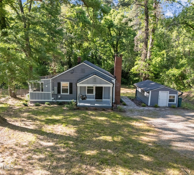 1613 Kilmer Ter, Durham, NC 27703 - bungalow-style home featuring covered porch, driveway, a chimney, an outbuilding, and a shed