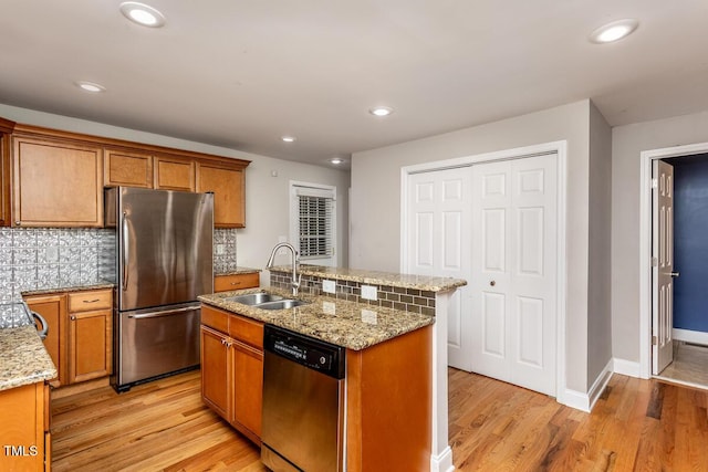305 Freeman St, Raleigh, NC 27601 - kitchen with stainless steel appliances, a sink, light wood-type flooring, backsplash, and a kitchen island with sink