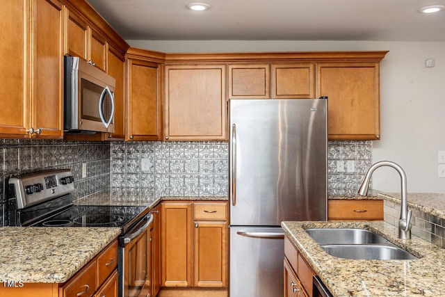 305 Freeman St, Raleigh, NC 27601 - kitchen with stainless steel appliances, a sink, light stone countertops, brown cabinets, and recessed lighting