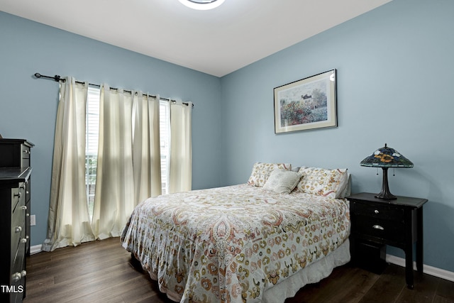 bedroom with dark wood-style flooring and baseboards