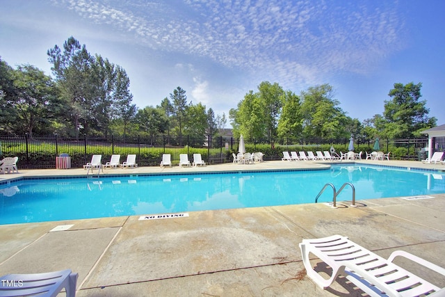 community pool featuring fence and a patio area