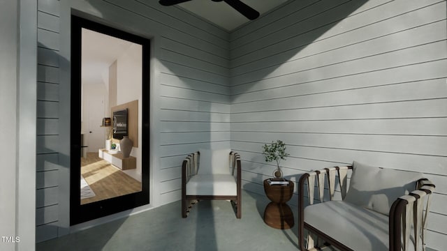1800 Pershing Rd, Raleigh, NC 27608 - sitting room with wood walls, ceiling fan, and finished concrete floors