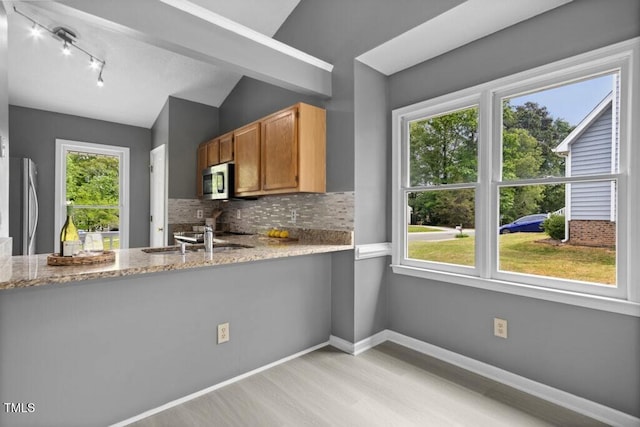 2402 Cynthia Dr, Durham, NC 27704 - kitchen with a sink, tasteful backsplash, light wood-type flooring, lofted ceiling, and appliances with stainless steel finishes