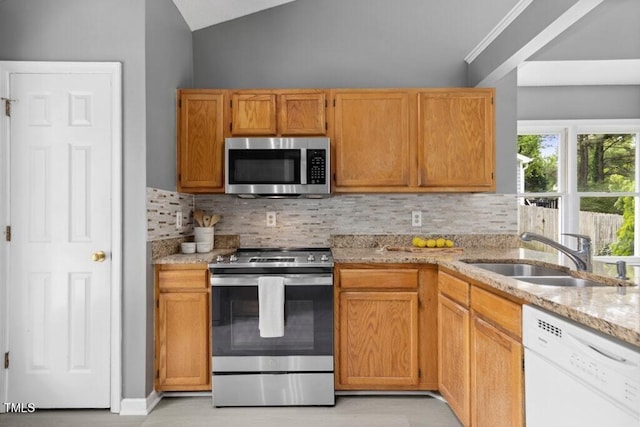 2402 Cynthia Dr, Durham, NC 27704 - kitchen featuring lofted ceiling, light stone counters, stainless steel appliances, backsplash, and a sink