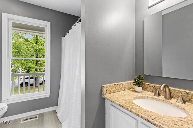 2402 Cynthia Dr, Durham, NC 27704 - full bathroom featuring baseboards, a healthy amount of sunlight, vanity, and visible vents