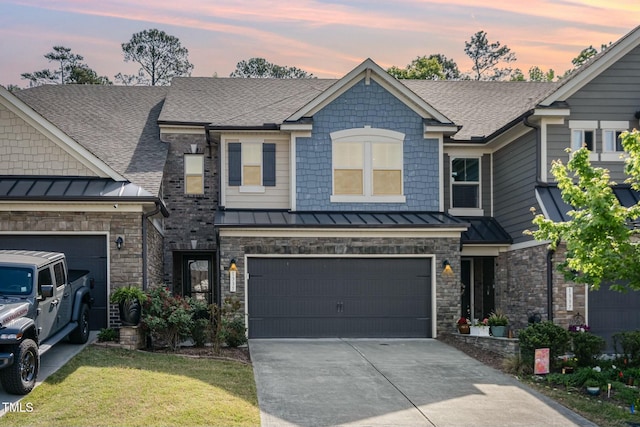 craftsman-style home featuring a standing seam roof, concrete driveway, and a shingled roof