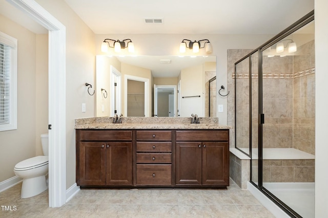 bathroom with a sink, a shower stall, toilet, visible vents, and double vanity