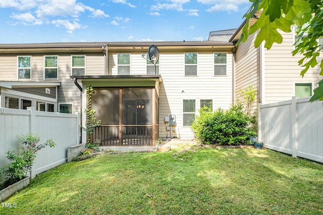 back of house with a sunroom, a yard, and a fenced backyard
