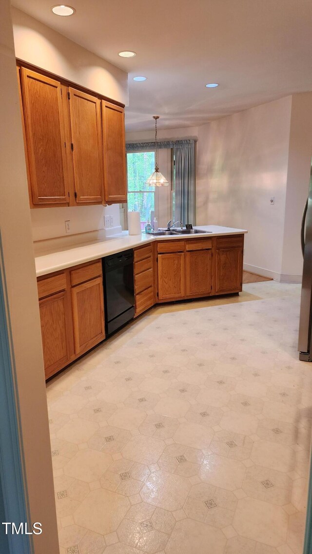 113 Colonial Dr, Wendell, NC 27591 - kitchen with brown cabinets, black dishwasher, a peninsula, and a sink