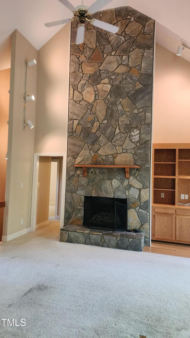 113 Colonial Dr, Wendell, NC 27591 - unfurnished living room featuring a ceiling fan, baseboards, a stone fireplace, carpet flooring, and high vaulted ceiling