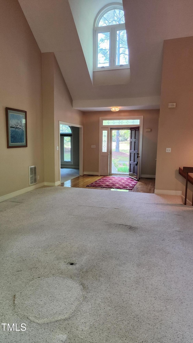 113 Colonial Dr, Wendell, NC 27591 - unfurnished living room with visible vents, baseboards, carpet floors, and high vaulted ceiling