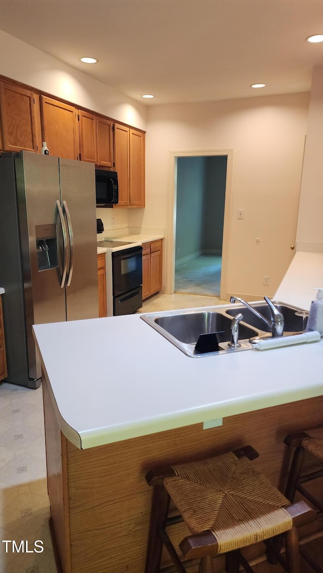 113 Colonial Dr, Wendell, NC 27591 - kitchen with a sink, black microwave, stainless steel fridge with ice dispenser, brown cabinets, and electric range