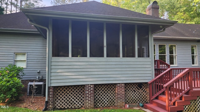 113 Colonial Dr, Wendell, NC 27591 - back of property featuring central air condition unit, a sunroom, a shingled roof, and a chimney