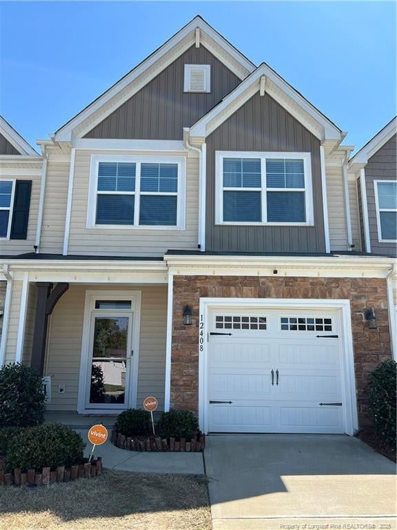 multi unit property featuring concrete driveway, stone siding, board and batten siding, and a garage