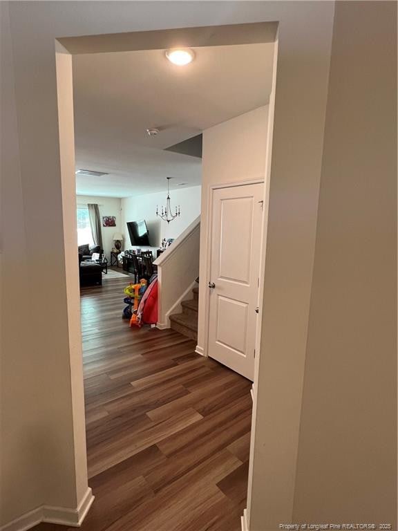 corridor featuring stairs and dark wood-style floors
