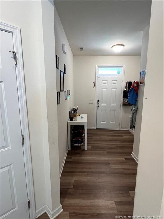 doorway to outside featuring baseboards, wood finished floors, and visible vents