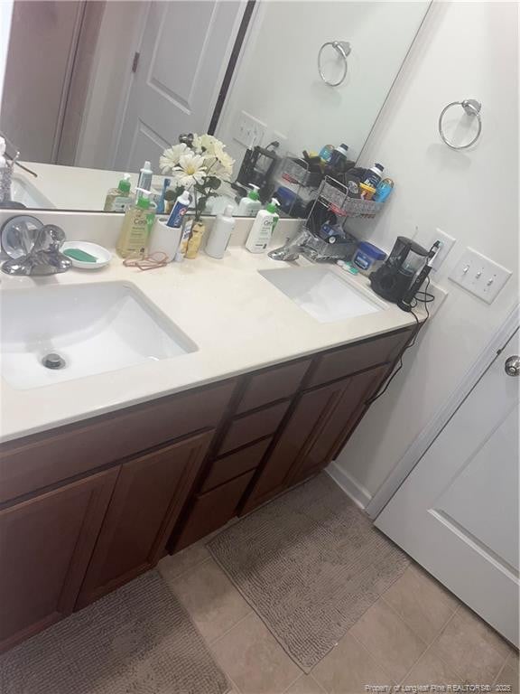 bathroom featuring tile patterned flooring, a sink, and double vanity
