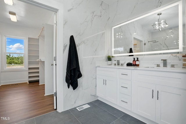 8629 Dukes Lake Rd, Zebulon, NC 27597 - bathroom featuring double vanity, a marble finish shower, and a chandelier