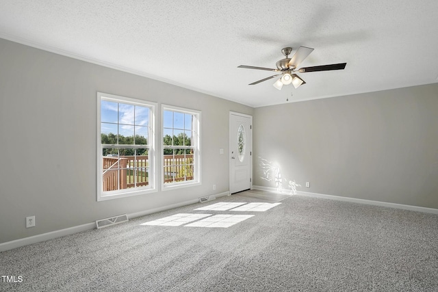 empty room with visible vents, baseboards, ceiling fan, a textured ceiling, and carpet flooring