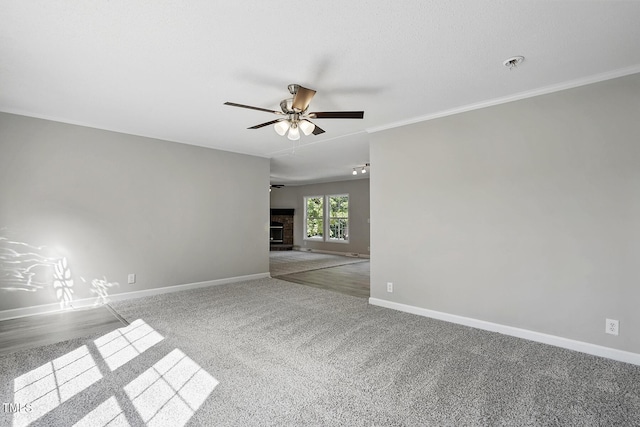 unfurnished room featuring crown molding, baseboards, a ceiling fan, and carpet flooring