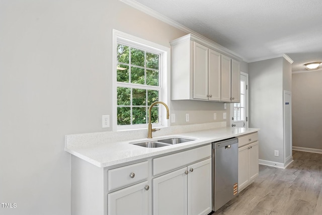 kitchen with a sink, light countertops, ornamental molding, and dishwasher